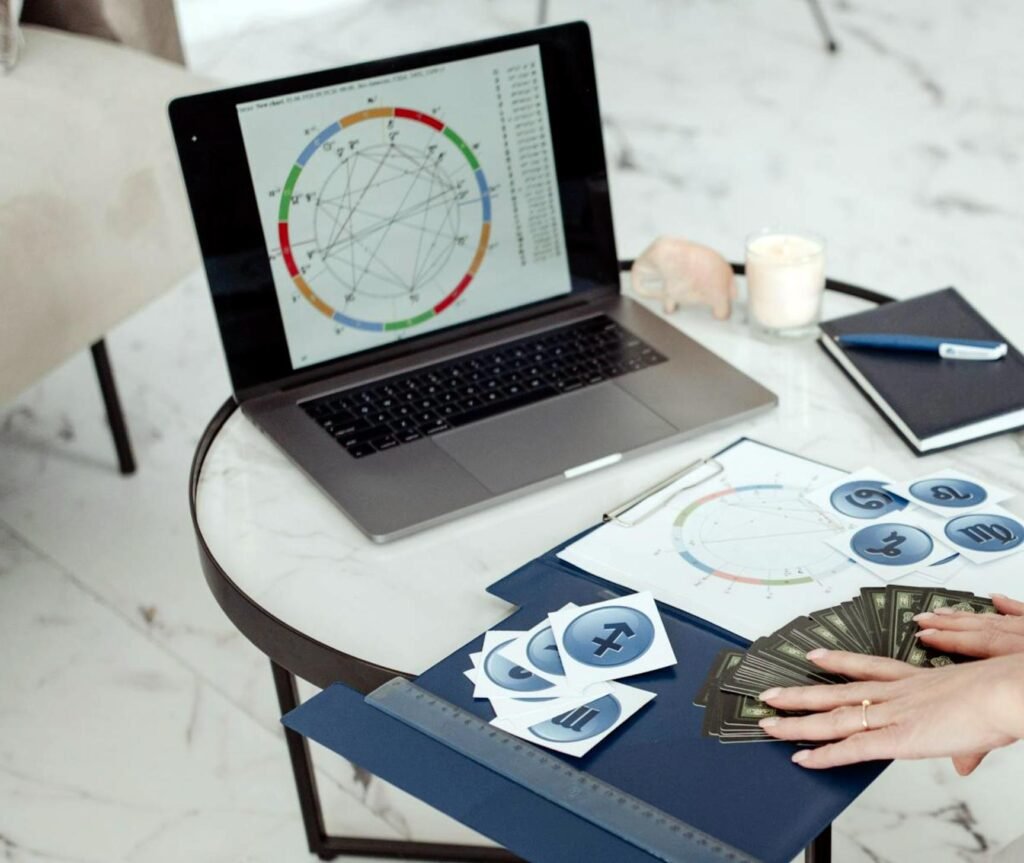 Career astrology consultation with a birth chart open on a laptop beside handwritten notes